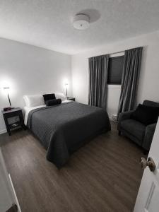 ein Schlafzimmer mit einem Bett, einer Couch und einem Stuhl in der Unterkunft Lotus Hideaway in Boston Bar