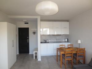 a kitchen and dining room with a table and chairs at Apartament Kamelia in Sopot
