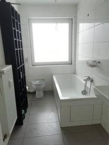 a bathroom with a tub and a toilet and a window at lichtdurchflutete 2 Zimmer Wohnung in Dinslaken
