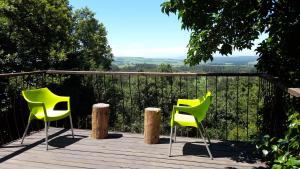 two yellow chairs sitting on a wooden deck at Evergreen Cabin Karkloof in Yarrow +24 photos