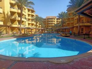 a large swimming pool in front of some buildings at Luxury Studio, pool, Private beach & close to Airport in Hurghada