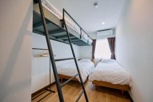two beds in a room with a bunk bed at Tood一宮 -E棟 in Ichinomiya