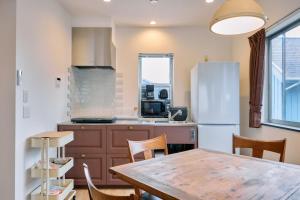 a kitchen with a table and a white refrigerator at Tood一宮 -E棟 in Ichinomiya