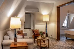 a hotel room with a bed and a living room at Warwick Brussels Grand-Place in Brussels +77 photos