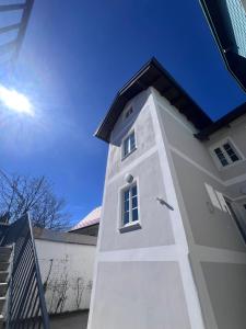 a white tower with a window on the side of a building at Vogelsang Apartments in Gmunden