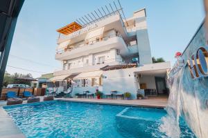 a hotel with a swimming pool in front of a building at Zogaj Hotel in Ksamil