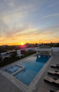 a pool with a sunset in the background at Luxury Prestige Villa in Midoun