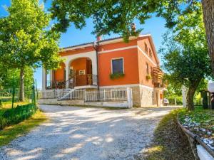 an orange house with trees in front of it at FalcoBianco GuestHouse in Montefalco