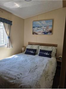 a bedroom with a bed with two pillows on it at Seabreeze in Goodrington