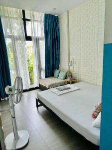 a bedroom with a large bed in a room with blue curtains at Dolphin Home in Dong Hoi