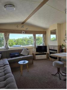 a living room with a couch and a tv at Seabreeze in Goodrington