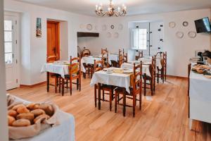 a dining room with tables and chairs and a kitchen at Casa de Campo da Quinta da Pegada in Óbidos