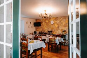 a dining room with tables and chairs and a tv at Casa de Campo da Quinta da Pegada in Óbidos