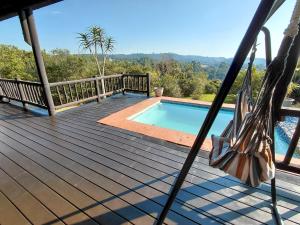 a deck with a swimming pool on a house at Sickle Bush Da Gama Lake in White River