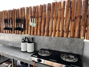 a kitchen with a stove and a wall of wooden logs at Stayhere Boracay Hostel in Boracay