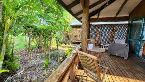 a porch of a house with a table and chairs at Aroa Kainga Bungalows and Apartment in Rarotonga