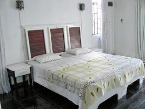 a white bedroom with a large bed and two windows at Apartments la Colombe in Mont Choisy