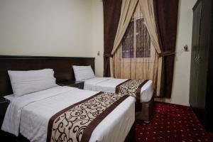 A bed or beds in a room at Qasr Zuwar Hotel