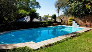 a large blue swimming pool in a yard at Gender Links Cottages in Johannesburg