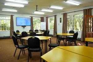 a classroom with tables and chairs and a projection screen at Gender Links Cottages in Johannesburg +263 photos