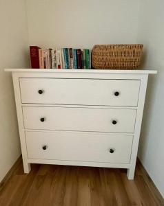 a white dresser with a basket on top of it at Vila Anička in Týnec nad Sázavou