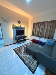 a living room with a couch and a flat screen tv at KRPV Homestay in Tambunan