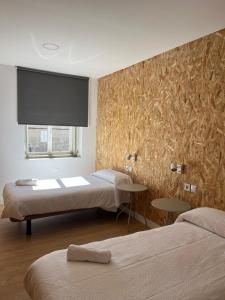 a room with two beds and a flat screen at Casa Bubela - Vía de la plata in Dozón
