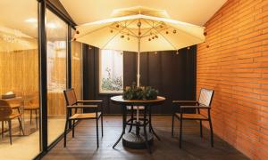 a table with chairs and an umbrella in a restaurant at Cheonan Asan Rosy Hotel in Asan