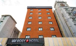 a tall red brick building with a sign on it at Cheonan Asan Rosy Hotel in Asan +89 photos