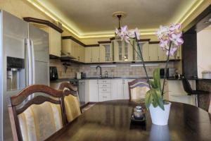 a kitchen with a table with a vase with flowers on it at Sziget Apartman in Pócsmegyer