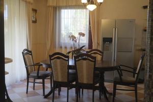 a kitchen with a table and chairs and a refrigerator at Sziget Apartman in Pócsmegyer +11 photos