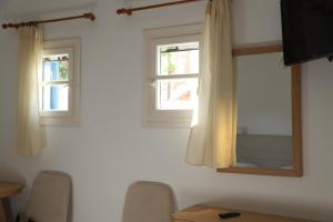 a room with a mirror and two windows at Romantika in Platis Gialos