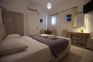a bedroom with a bed with towels on it at Romantika in Platis Gialos