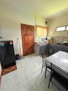 a kitchen with a table and a wooden door at KRPV Homestay in Tambunan