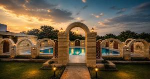 a building with a pool with a sunset in the background at Gir Wildtrack Lodge - Into the Deep Forest in Sasan Gir