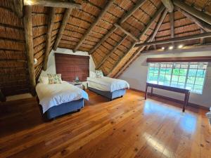 a attic bedroom with two beds and a window at Pearse Farm Stay in Howick +105 photos