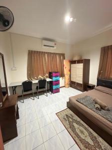 a bedroom with a bed and a table and chairs at KRPV Homestay in Tambunan +2 photos