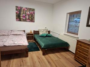 a bedroom with a bed and a chair and a window at Chatka Kurki in Kurki