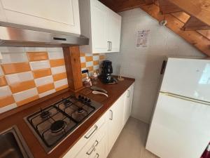 a kitchen with a stove and a white refrigerator at Dimora Li Vinti in Cicciano