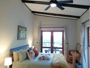 a bedroom with a bed with a ceiling fan at Sickle Bush Da Gama Lake in White River +22 photos