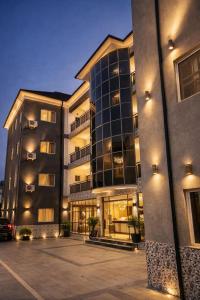 a large building with a parking lot in front of it at Lake Court Residence in Abuja