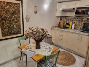 a kitchen with a table with a vase of flowers on it at Mediterranean Breeze Studio in Sidi Bou Saïd