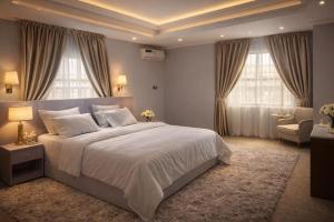 a bedroom with a large white bed and windows at Lake Court Residence in Abuja