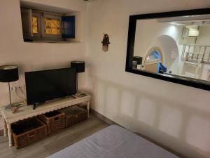 a living room with a tv and a mirror at Mediterranean Breeze Studio in Sidi Bou Saïd +9 photos
