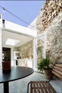 a dining room with a table and a stone wall at Casa Sol in Denia