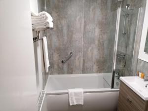 a bathroom with a shower with a tub and a sink at Castle Hotel in Devizes