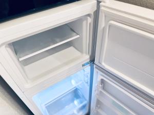 an empty refrigerator with its door open and its drawer at Hotel Suite1 Quiet Family Stay Near Tokyo in Warabi