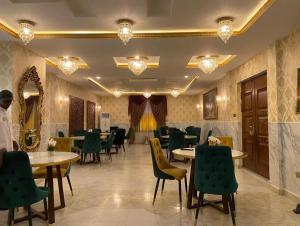 a restaurant with tables and chairs in a room at Lake Court Residence in Abuja