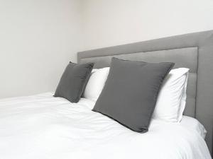 a bed with two gray pillows on top of it at Hotel Suite1 Quiet Family Stay Near Tokyo in Warabi