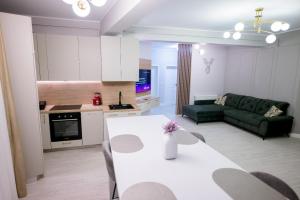 a kitchen and living room with a table and a couch at Apart Hotel Nordic Residence 16H in Suceava +49 photos